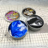 A collection of Camo Masking Putty tins and a blue putty in a metal container on a grid surface.