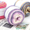 Rolls of gradient rainbow yarn in various colors and textures for knitting and crochet projects