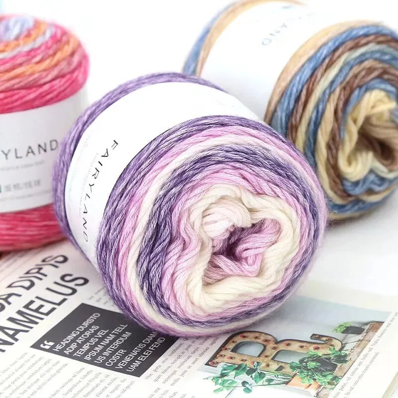 Rolls of gradient rainbow yarn in various colors and textures for knitting and crochet projects