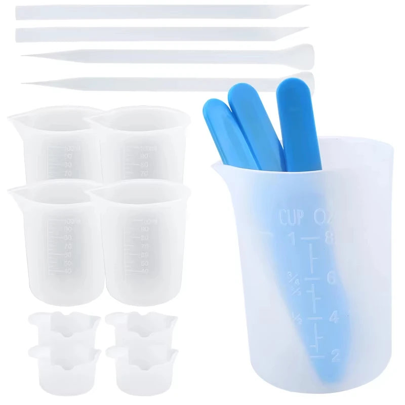 A set of reusable silicone resin mixing tools including measuring cups and blue stir sticks.