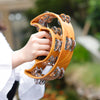 A person is holding a wooden tambourine with metal bells for kids.