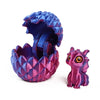 A purple and pink dragon egg surprise figurine with textured scales and large eyes.