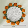 Hand-crocheted lily of the valley coasters featuring white and orange yarn in a circular pattern