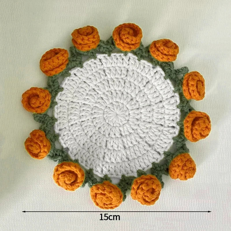 Hand-crocheted lily of the valley coasters featuring white and orange yarn in a circular pattern