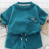 A teal boys' summer cotton t-shirt and shorts set featuring a textured knit fabric.