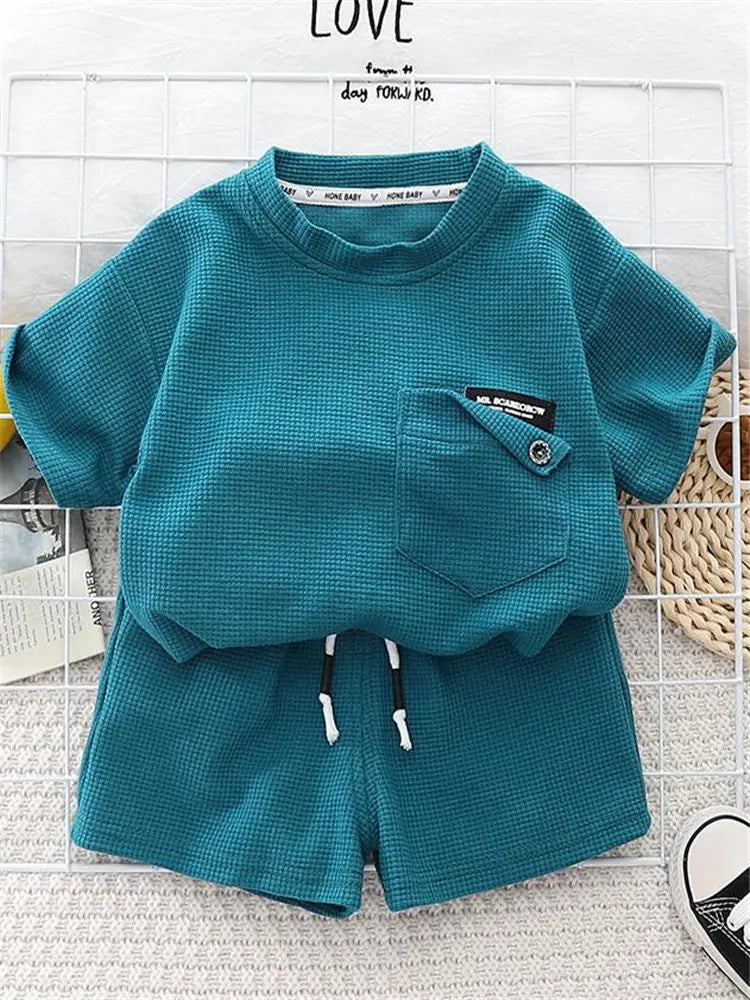 A teal boys' summer cotton t-shirt and shorts set featuring a textured knit fabric.