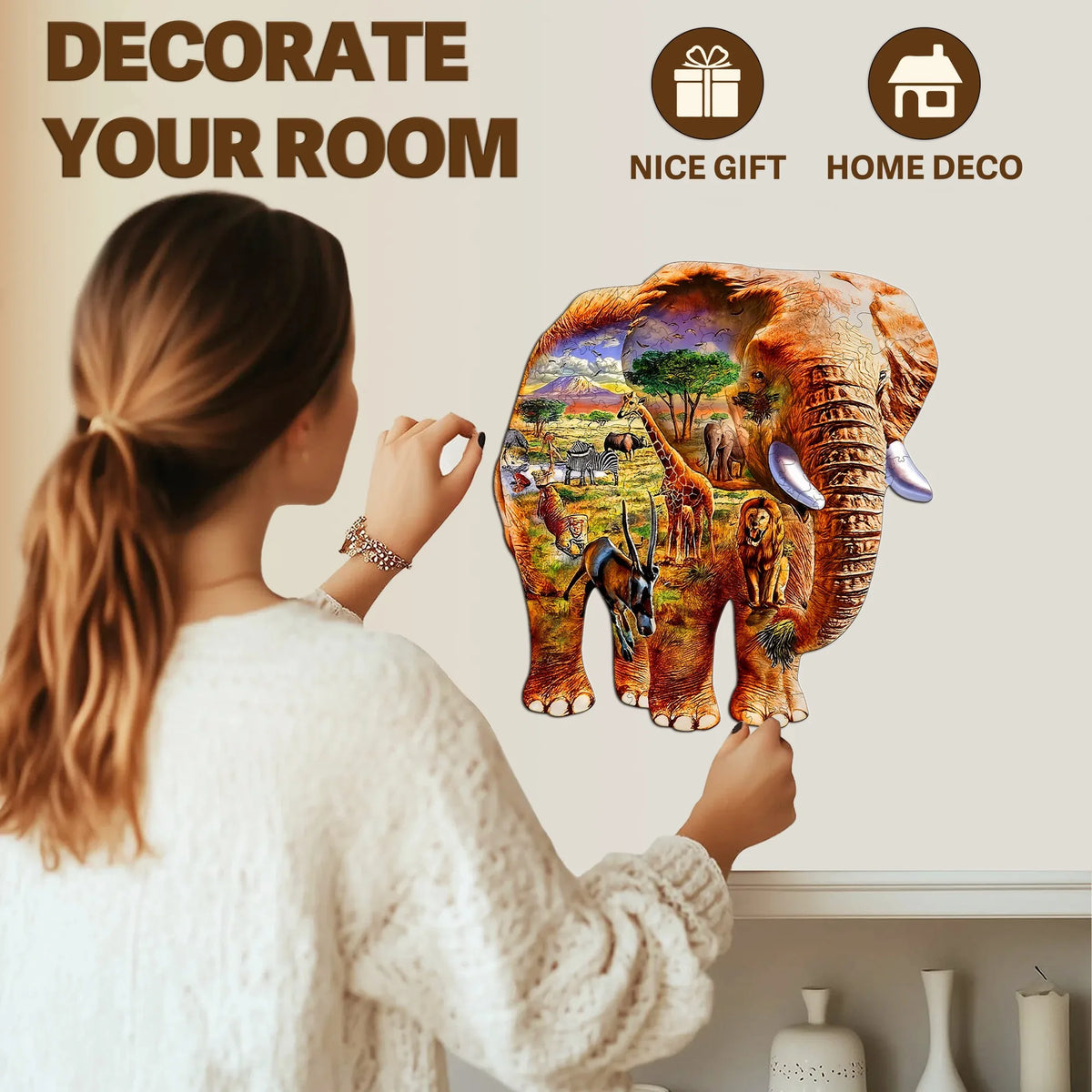 A woman is decorating a room with an elephant-themed wooden jigsaw puzzle for kids.