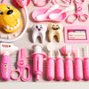 A collection of pink and yellow kids doctor play set accessories including a stuffed dog, dental tools, and various medical i
