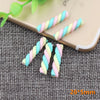 A collection of ten polymer clay marshmallow charms in pastel colors are displayed on a light-colored smartphone.