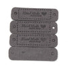 A set of two dark gray leather-style handmade with love tags for crafts and sewing.