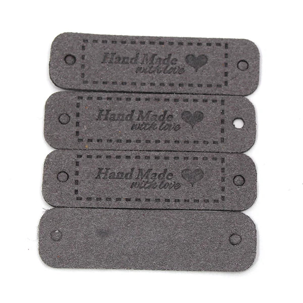 A set of two dark gray leather-style handmade with love tags for crafts and sewing.