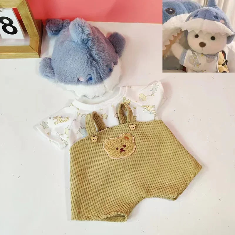 A fluffy blue teddy bear plush wearing a light-colored outfit is displayed next to a wooden frame.