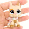 A small, light beige cat figure wearing a multicolored knitted scarf is held in a person's hand.
