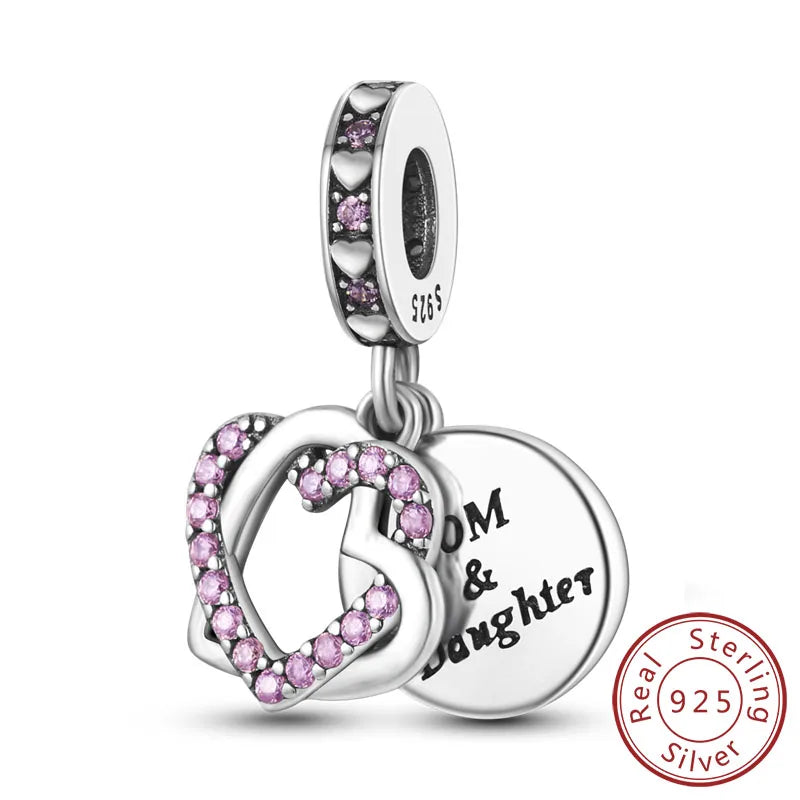 A sterling silver heart charm bead with pink stones and a tag engraved with Mom & Daughter