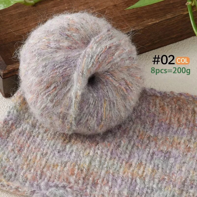 A ball of light gray and purple alpaca blend yarn resting on a knitted item.