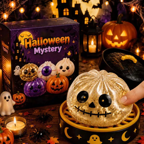 A golden Halloween mystery box featuring various pumpkin-shaped squishy toys and a large glittery pumpkin face.