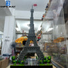 A detailed miniature model of the Eiffel Tower built from gray building blocks displayed in a glass case.