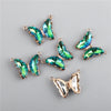 A set of crystal butterfly charm beads in green and blue tones for jewelry making.