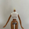 A brown doll with a white knitted top and a blonde hairpiece, shown from the back.