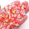 A hand holds a pile of assorted polymer clay slices in various colors including red pink and white for DIY crafts