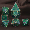 A set of seven green metal polyhedral dice, including a pyramid and dodecahedron shapes, displayed on dark fabric.
