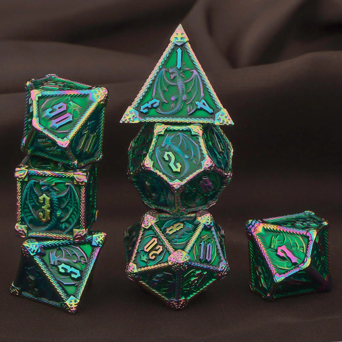 A set of seven green metal polyhedral dice, including a pyramid and dodecahedron shapes, displayed on dark fabric.