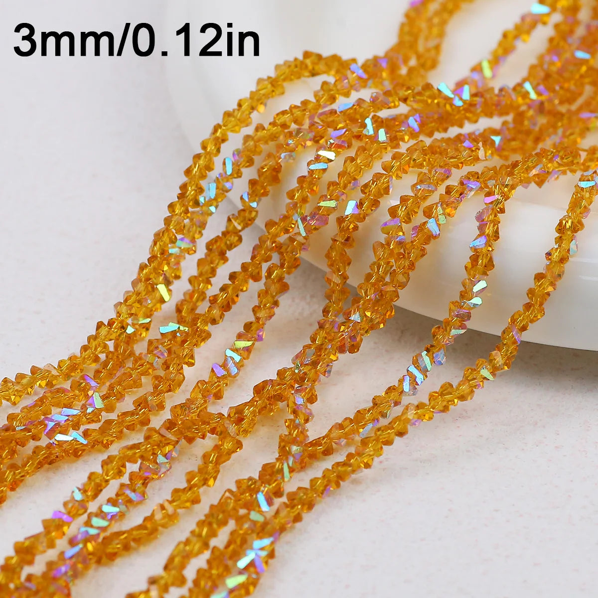 A close-up of strands of sparkling orange crystal triangle beads for jewelry making