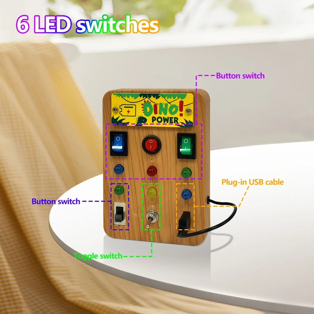 A wooden busy board with six LED switches and a button switch, featuring various colored buttons and a plug-in USB cable.