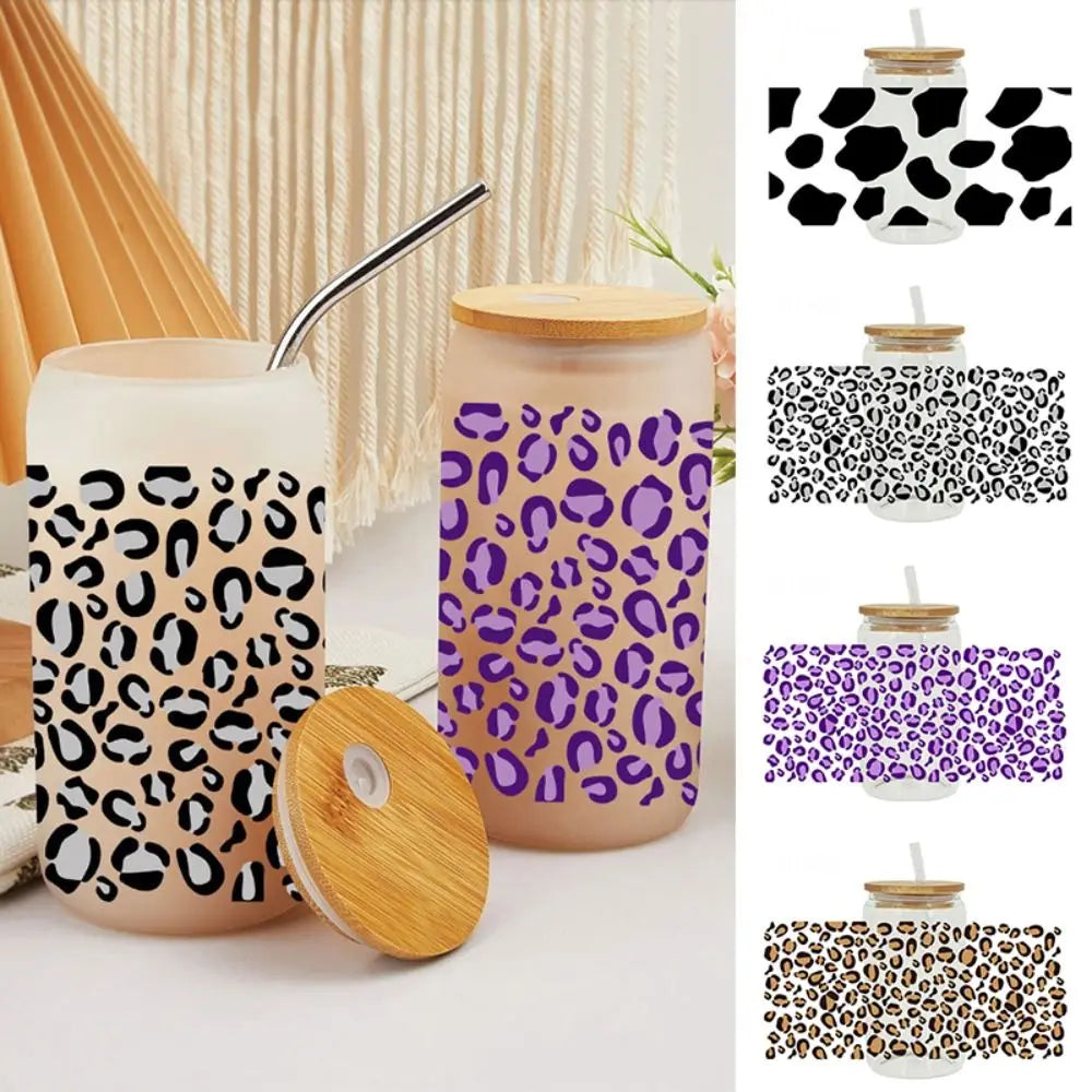 A set of leopard print UV DTF cup wraps featuring black and purple patterns on clear glass cups.