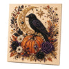 A framed canvas featuring a detailed illustration of a black bird and a crescent moon surrounded by floral and autumnal eleme