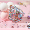 A box of Doll stickers featuring characters and scenery is displayed next to several white, round objects.