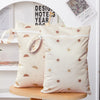 A set of two beige reusable waterproof baby wet bags with a sun pattern displayed on a white shelf.