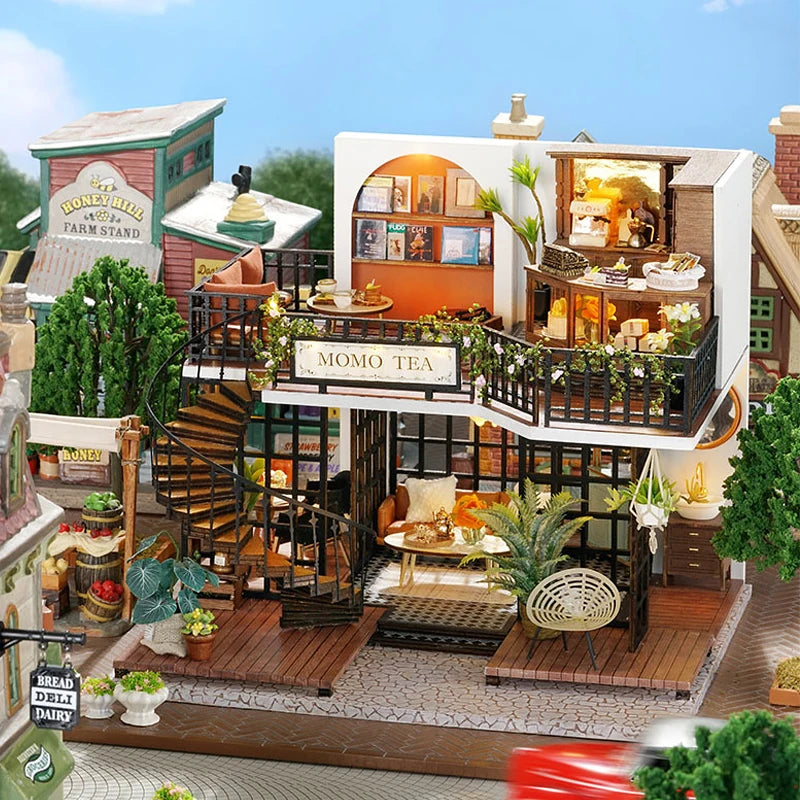 A detailed miniature dollhouse scene featuring a Momo Tea shop and surrounding architecture.