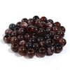 A pile of dark brown, polished imitation jade acrylic cloud beads for jewelry making and crafts.