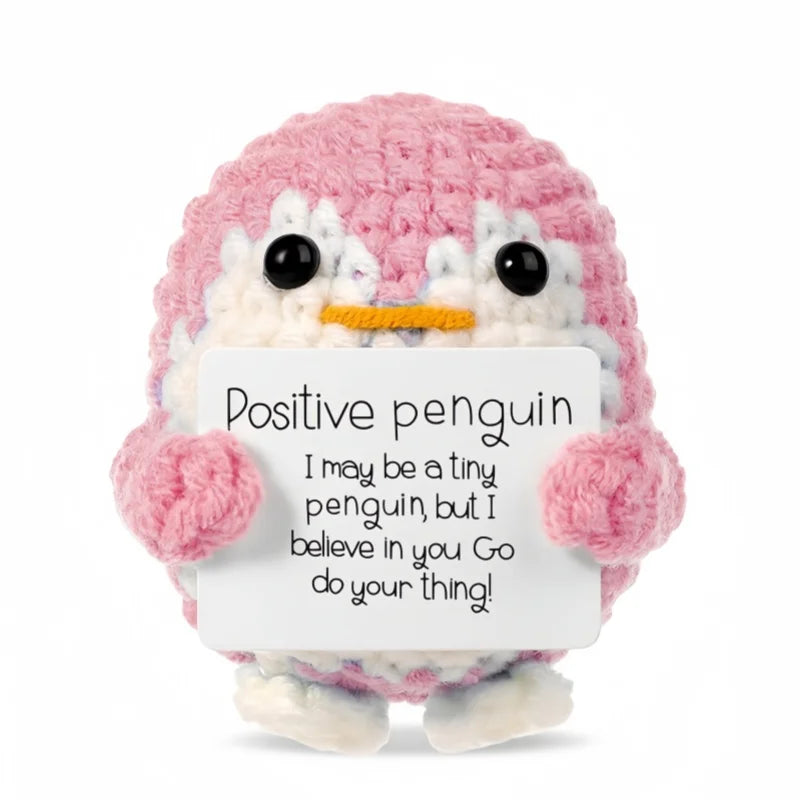 Handmade crochet pink penguin doll holding a card with the message I may be a tiny penguin but I believe in you Go do your th