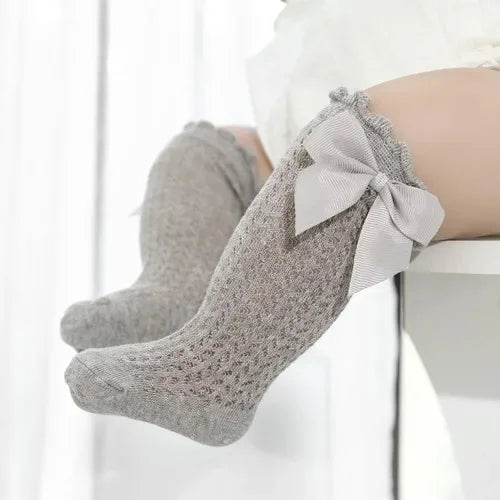 Gray lace knee socks for a baby girl with a decorative bow