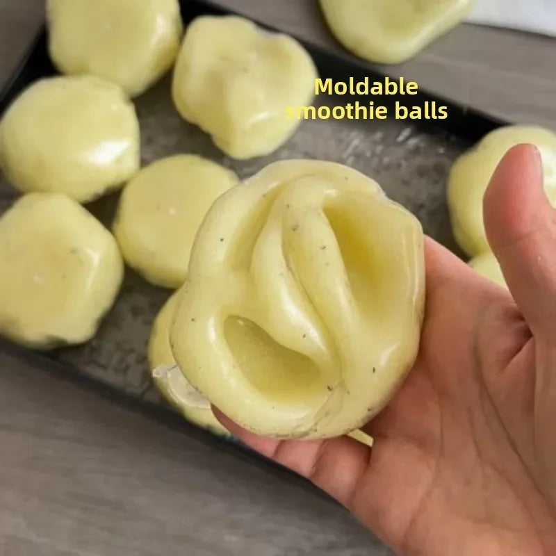 A hand holds a molded potato-shaped stress reliever ball on a dark plate.