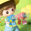 A cartoon child is shown using an electric bubble machine toy to create bubbles.