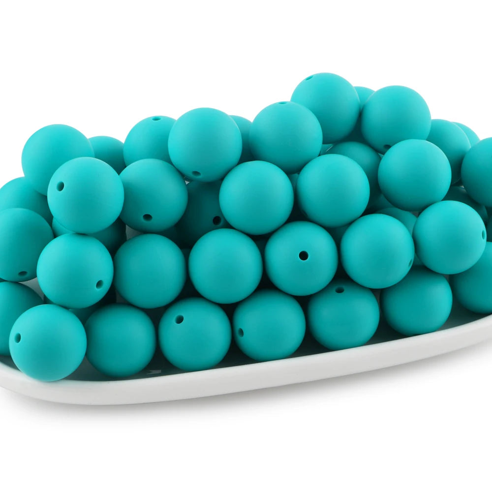 A pile of teal silicone beads for jewelry making and DIY crafts.