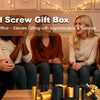 Five people are gathered around a wooden table displaying nested screw gift boxes for cash and gifts.