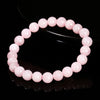 A bracelet made of smooth, round pink quartz beads arranged in a circle.