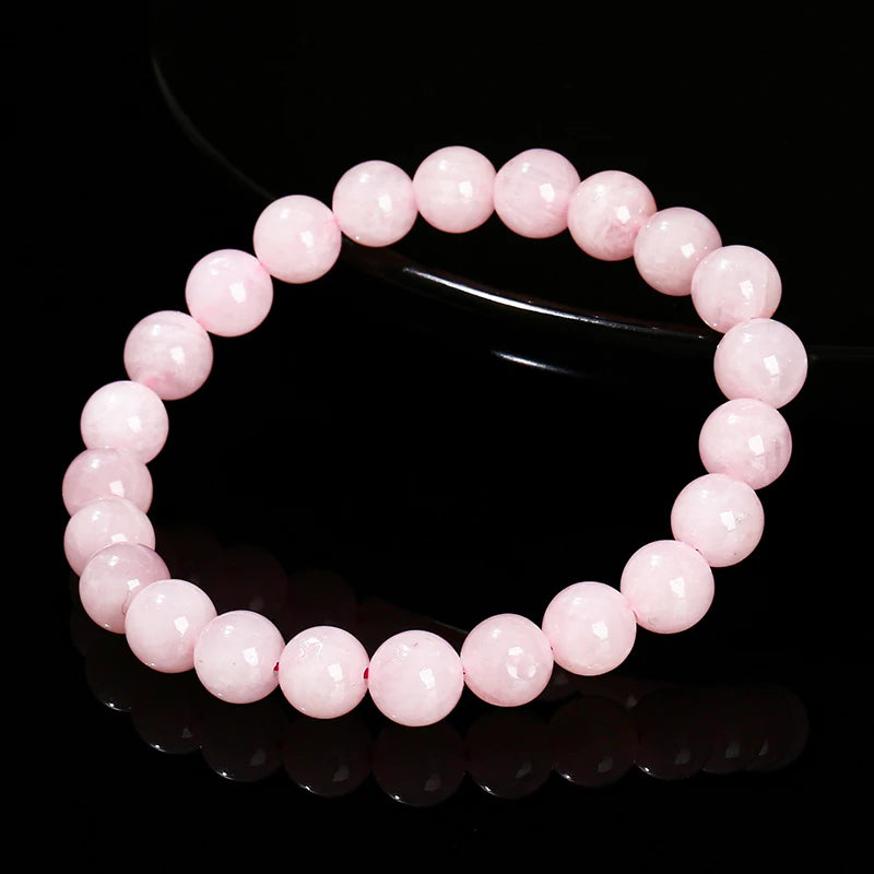 A bracelet made of smooth, round pink quartz beads arranged in a circle.