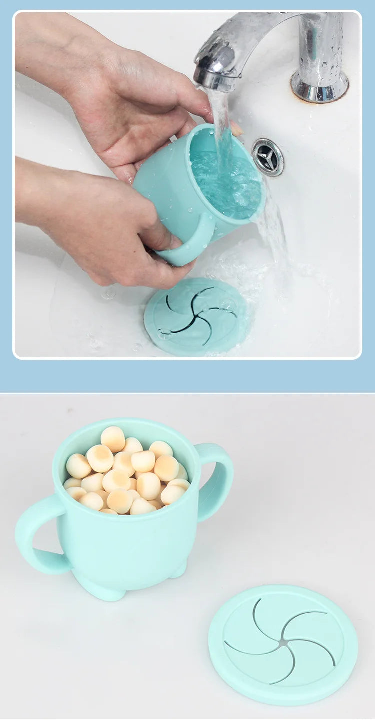 A light blue silicone snack cup with a lid is being rinsed under running water.