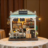 A detailed miniature wooden dollhouse kit of a coffee shop with an awning and interior display.