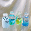 Four clear glass bottles filled with colored liquid labeled Chiboki drink cup for sensory relaxation