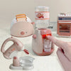 A pink kids pretend play kitchen set featuring a coffee maker, water dispenser, and toaster on a white surface.