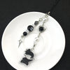 Anime-inspired keychain featuring black and white charms including a star and a character silhouette