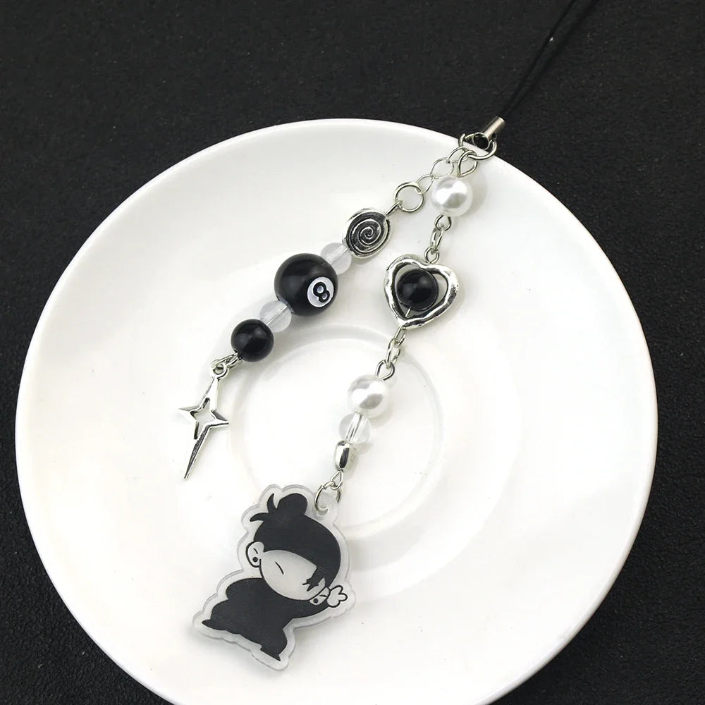 Anime-inspired keychain featuring black and white charms including a star and a character silhouette