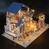A detailed miniature dollhouse kit of a seaside beach house with an upper balcony and exterior features.