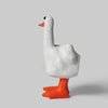 A white resin figurine of a goose with an orange beak and feet, depicted in a humorous pose.